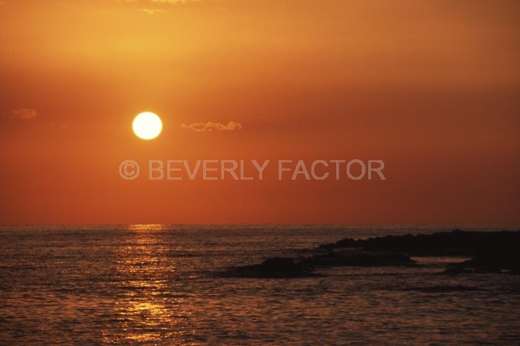 Islands;sunsets;sky;clouds;colorful;blue water;sun;yellow;red;pink;sillouettes;blue;hawaii